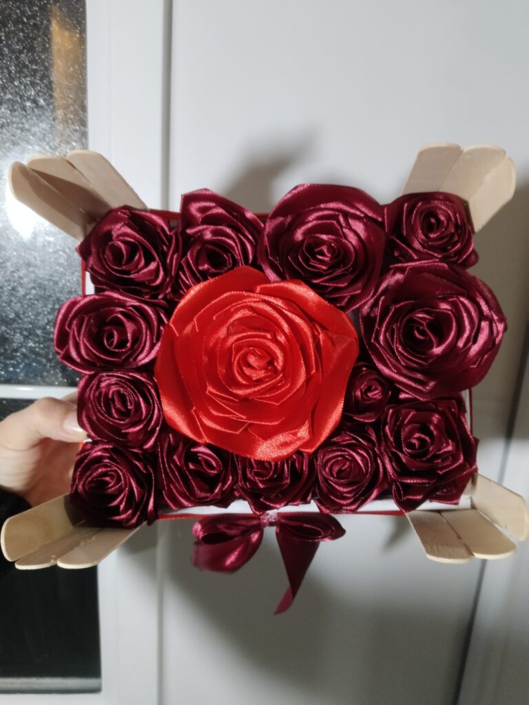 Crvene satenske ruže sa jednom velikom ružom u sredini – ručno rađeni elegantan aranžman, idealan poklon ili dekoracija za proslave