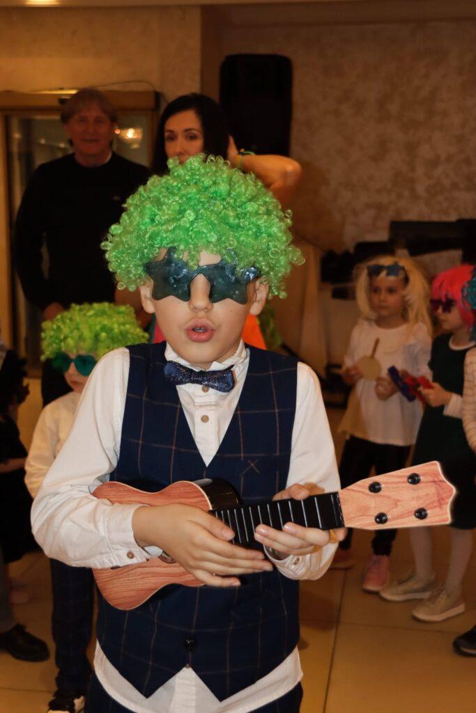 slika sa dečijeg rođendana gde slavljenik svira gitaru - dečiji fotograf Beograd